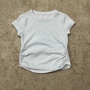 A white t-shirt with ruffles on the side